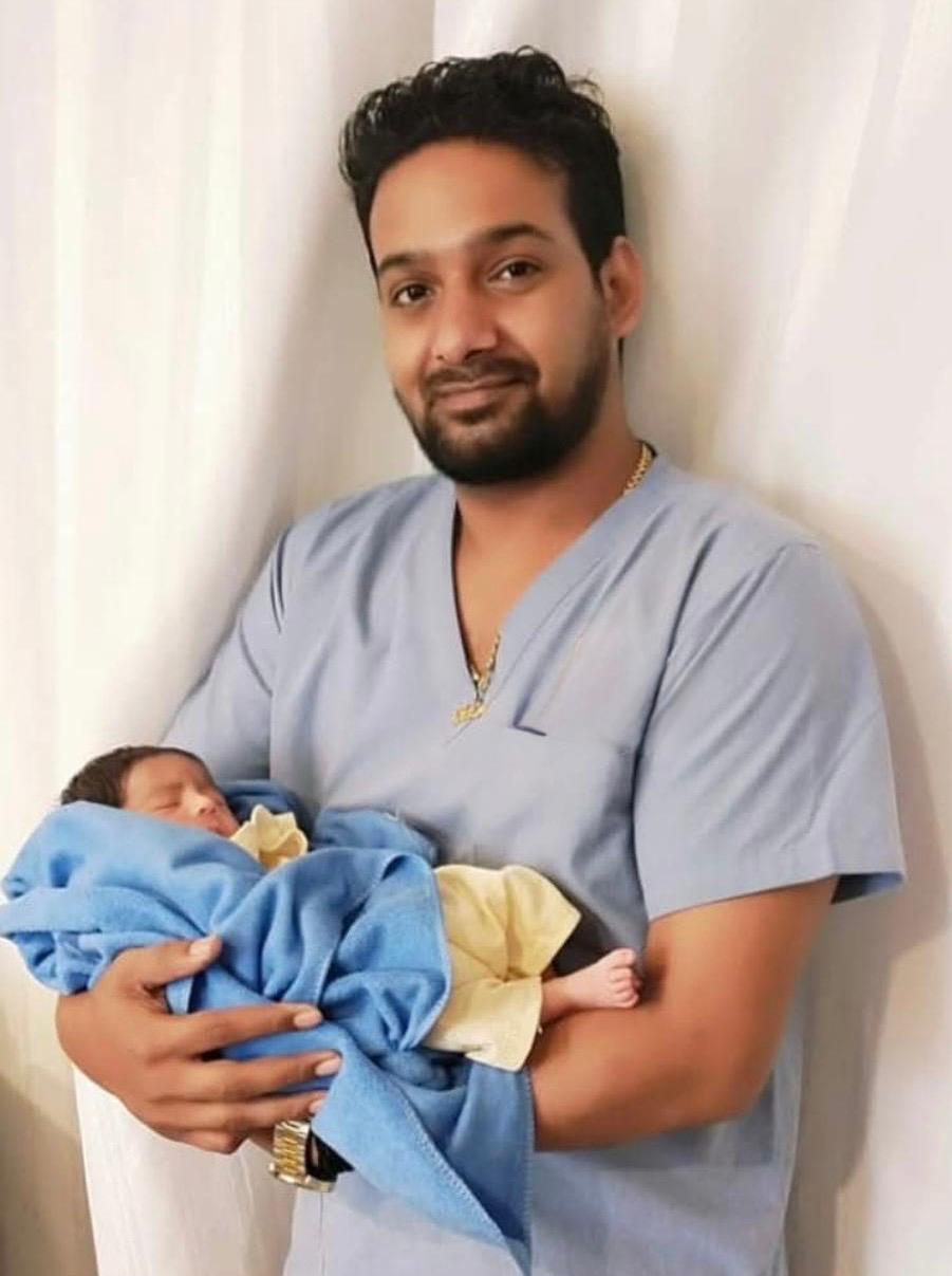 Our Embryologist holding a newborn baby at GHRACE & HOPE IVF representing a successful fertility treatment and parenthood journey.
